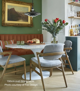 150cm Oval marble tulip dining table with a central aluminium base, presented in a choice of sizes. The table is set in a room with four wooden chairs, and there is a vase with flowers on the table.