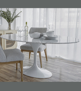 An oval Italian marble tulip dining table with a bevelled and tapered edge, placed on an aluminium lacquered stem base.