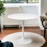 A white tulip dining table with a wooden top and an aluminium base.