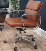 low back office chair in vintage tan leather with chrome swivel base in an office.