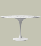 A round solid marble tulip dining table with a white lacquered aluminium stem base.