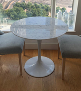 A round marble dining table in white Carrara Italian marble.