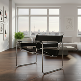Wassily Marcel Breuer style armchair in black leather with chrome tubular frame on white background.