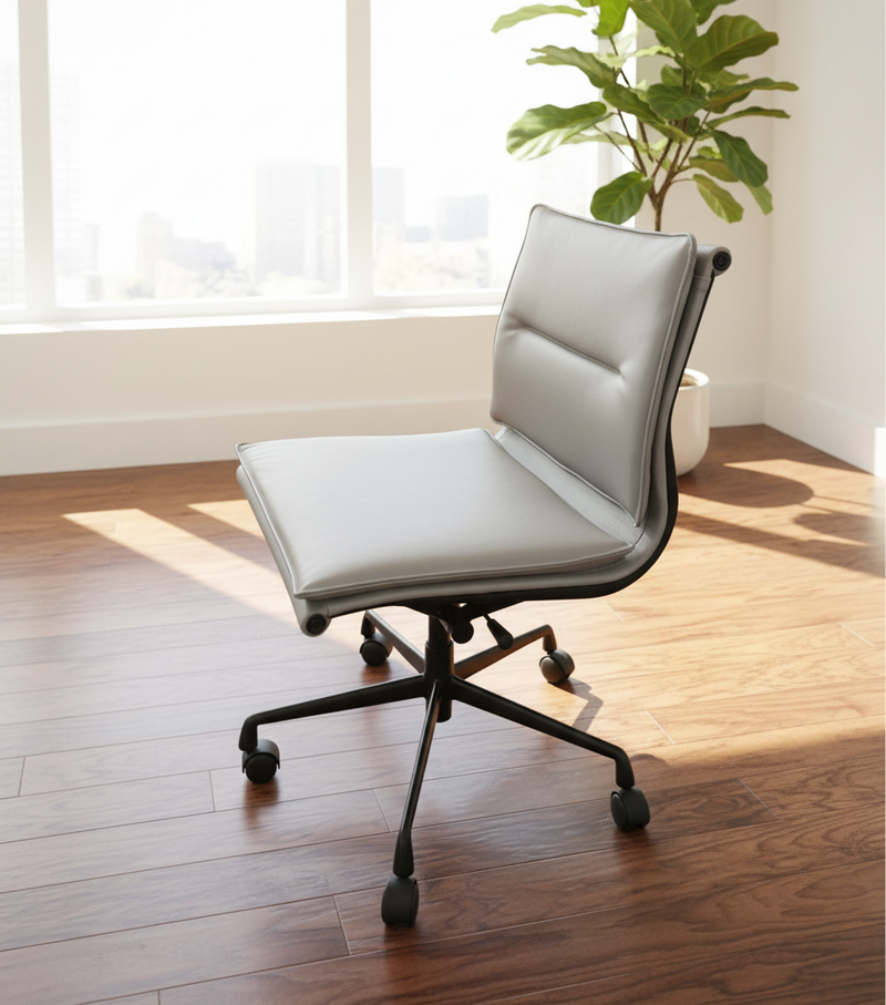 Modern office chair with light grey cushioned seat and black frame in a room with wooden floor and plant.