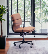 A mid-century style office chair with a black powder coated frame and full premium leather upholstery, featuring a five-star base with castors.