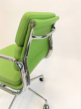 Close-up of ow back office chair in apple green leather with chrome frame on white background.